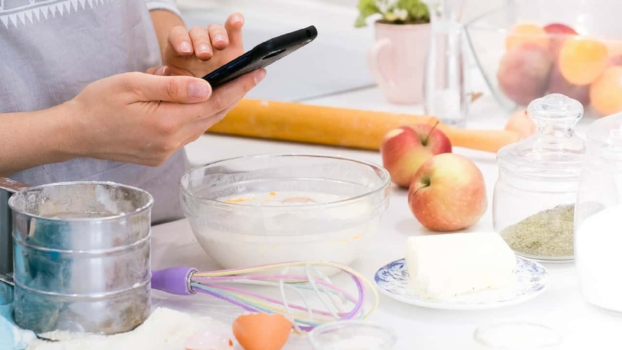 What Is a Digital Product & How To Sell Profitable Digital Products 3 Person using phone while baking