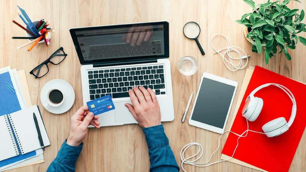 Person inputting credit card numbers into a laptop