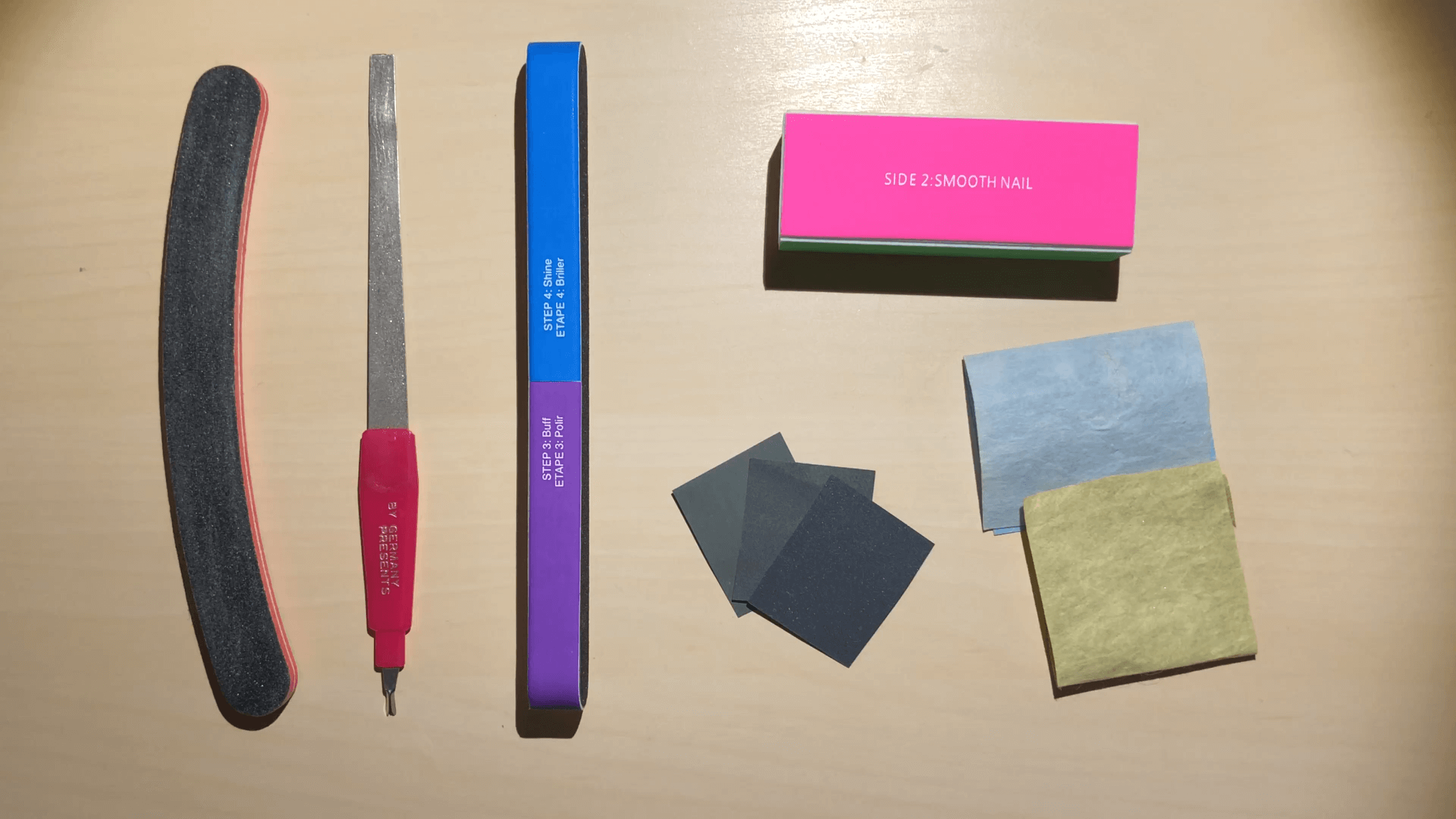 A few tools you can use for shaping your nails including a metal file, multi-sided buffer, and polishing papers.