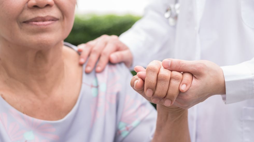 Patient holding doctor's hand