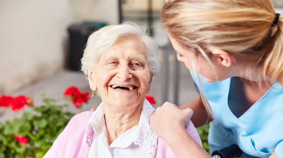 carer talking and smiling with elderly patient