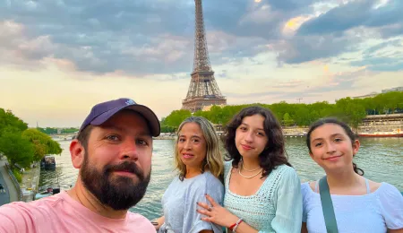 Family taking selfie in front of the. Eiffel Tower.