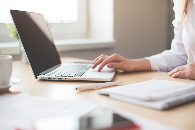A woman using her personal computer on a desk