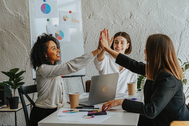 Women colleagues high-fiving