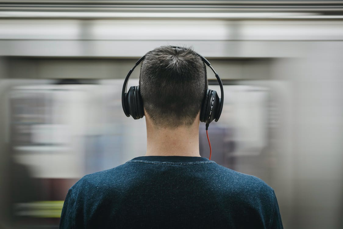 Man wearing headphones at a subway station