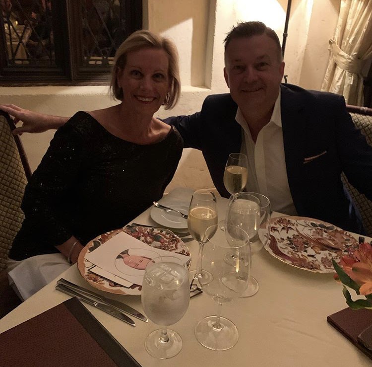 Two people smiling as they enjoy a romantic dinner together on a Blueboard reward experience.