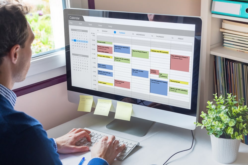 Man Scheduling Meetings on Calendar