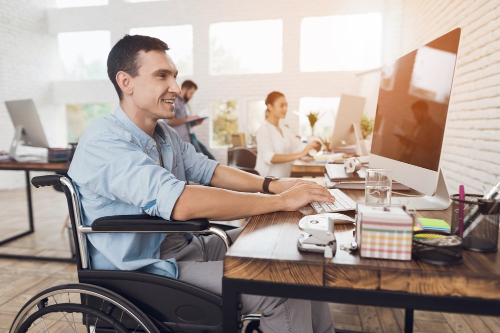 Man in Wheelchair Working Productively at Office