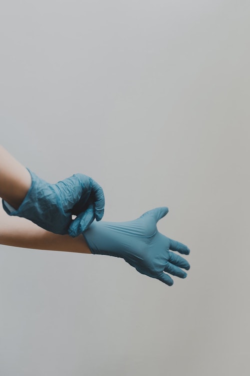 person putting on gloves to prepare for cleaning