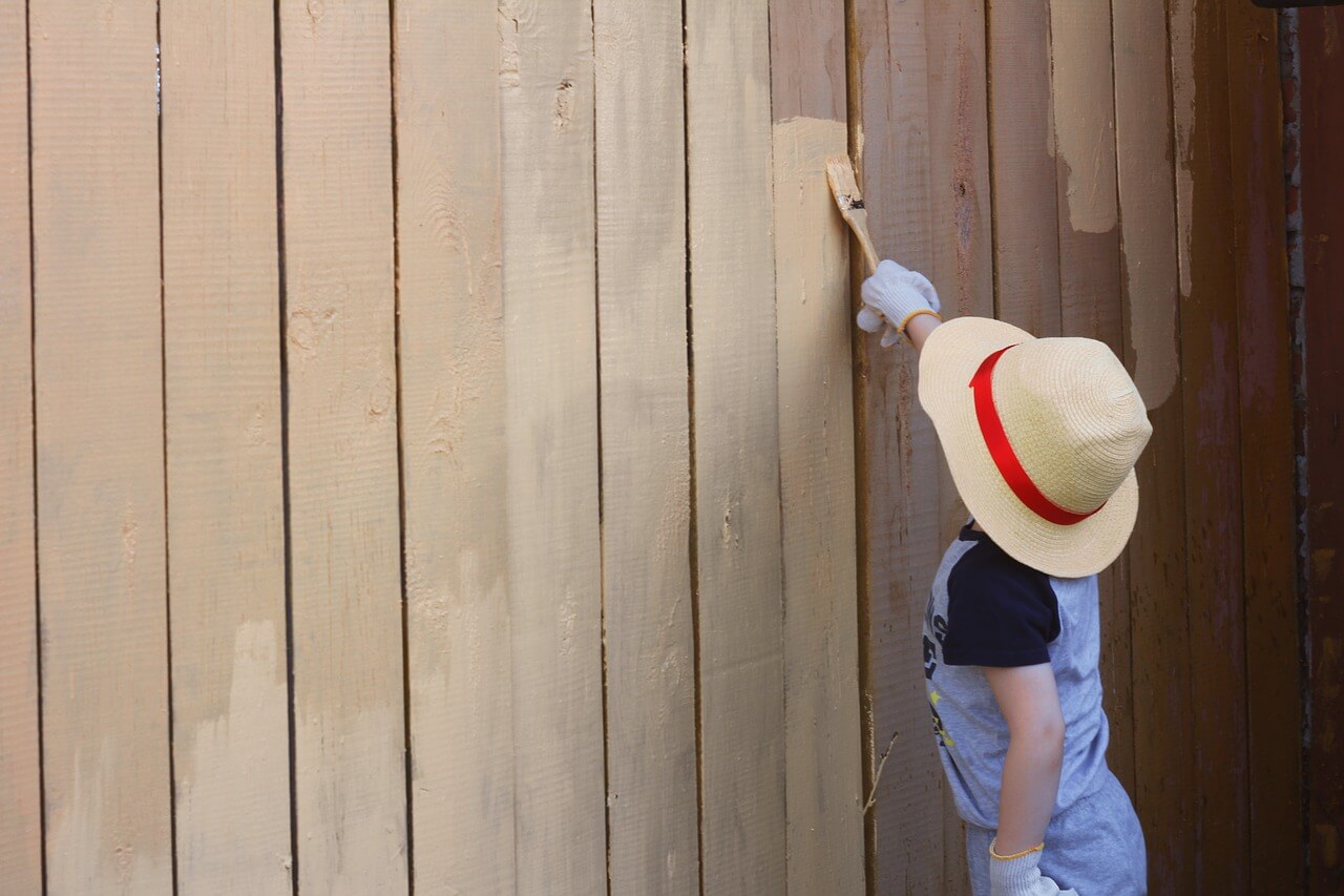 boy painting a fence