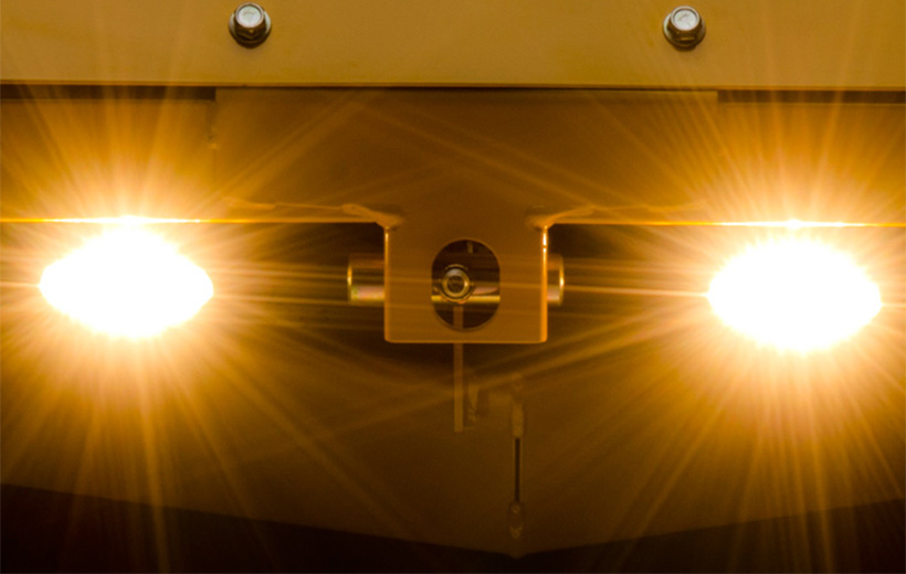 Image of lights mounted on the front of a yellow mower