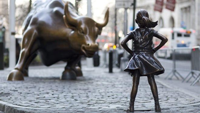 In this March 22, 2017 photo, the Charging Bull and Fearless Girl statues are sit on Lower Broadway in New York.