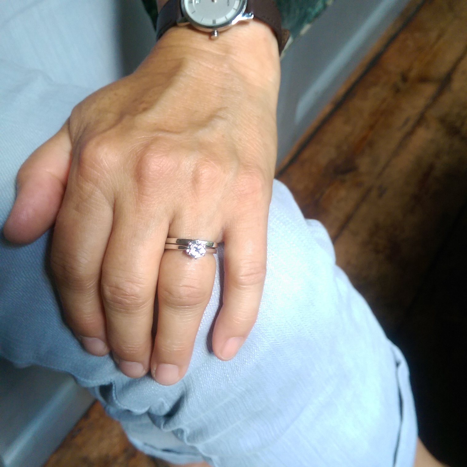 Finished trapezoid shaped engagement wedding and engagement ring on client hand.