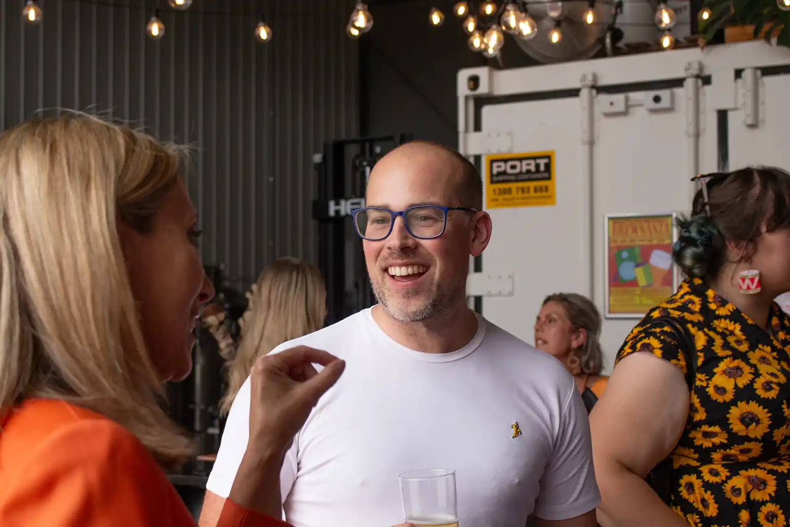a man in a white t-shirt with a beer in his hand