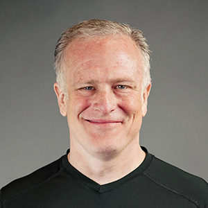 middle aged man with soft smile and short blonde hair