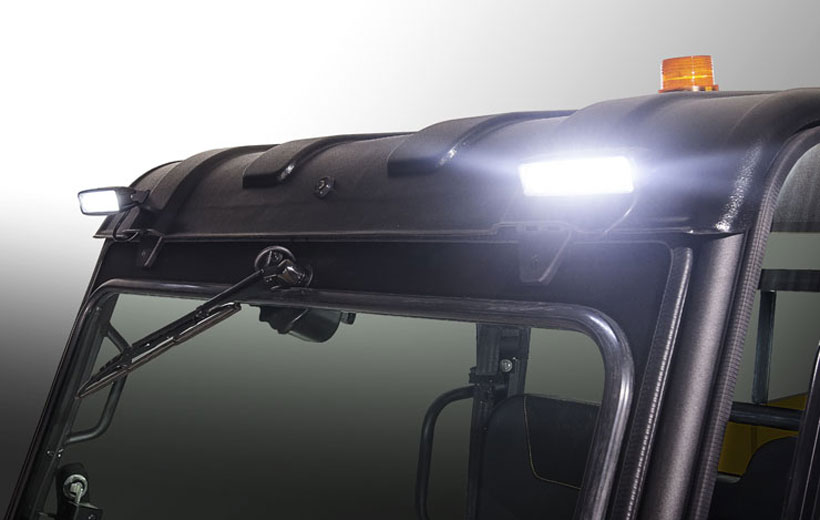 Image of the front roof line of a utility vehicle with lights that are turned on mounted on it.