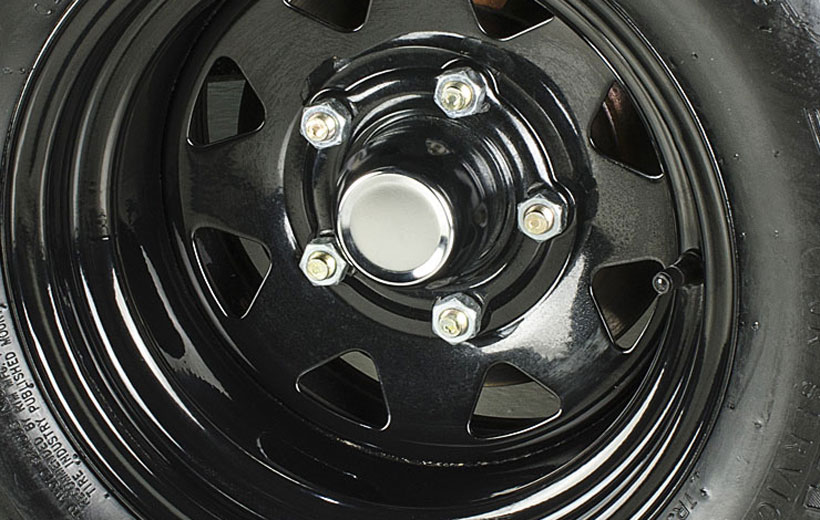Image close up on a utility vehicle wheel showing a cap in the center.