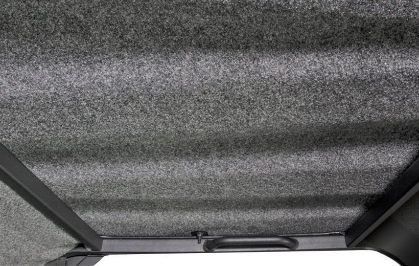 Image of the inside of a utility vehicle roof with gray material on it.