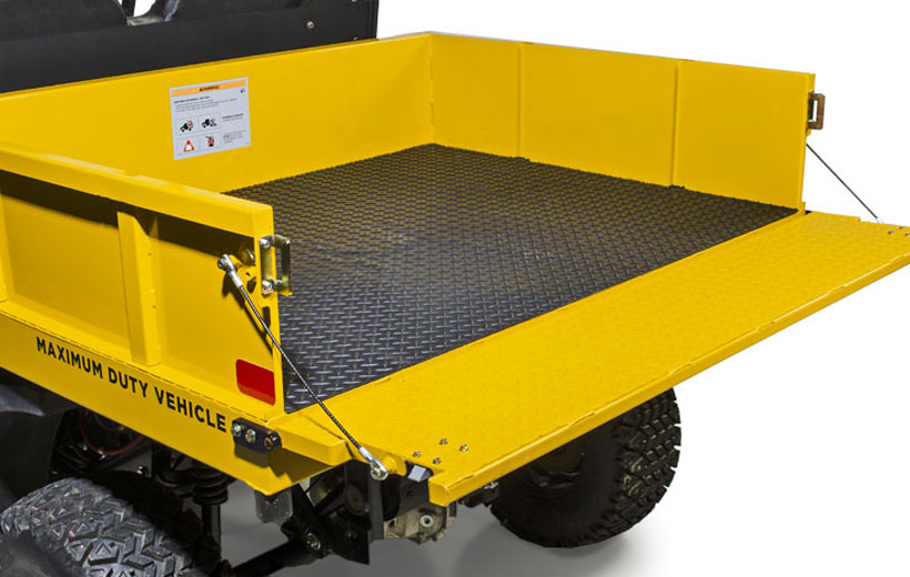 Image of the bed of a utility vehicle with the gate down and a black mat visible lining the bed.