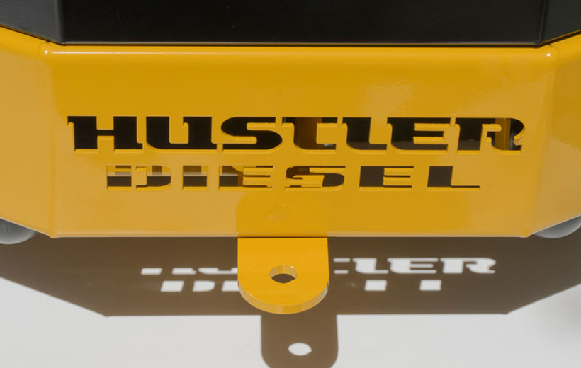 Image of the back a mower with a rounded yellow metal piece with a hole in it attached to the back.