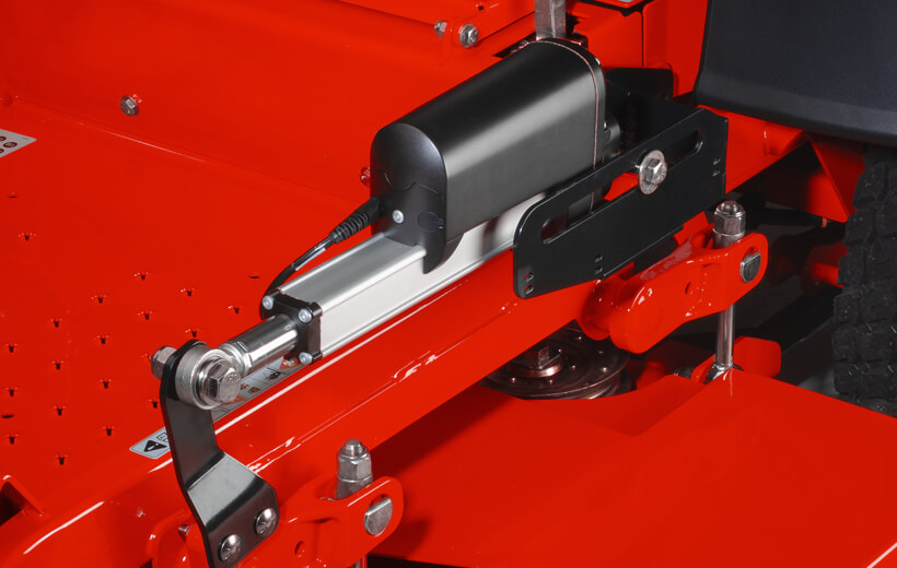 Image of an black electric accuator mounted on a bar above a mower deck