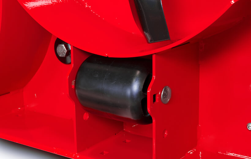 Image of the underside of a red mower deck with a black wheel mounted between plates of steel