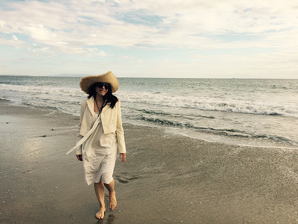 Photo of Cathy Waterman walking on the seashore.