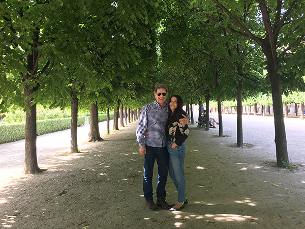 Photo of Cathy Waterman and her husband, Eddie, standing under some trees.