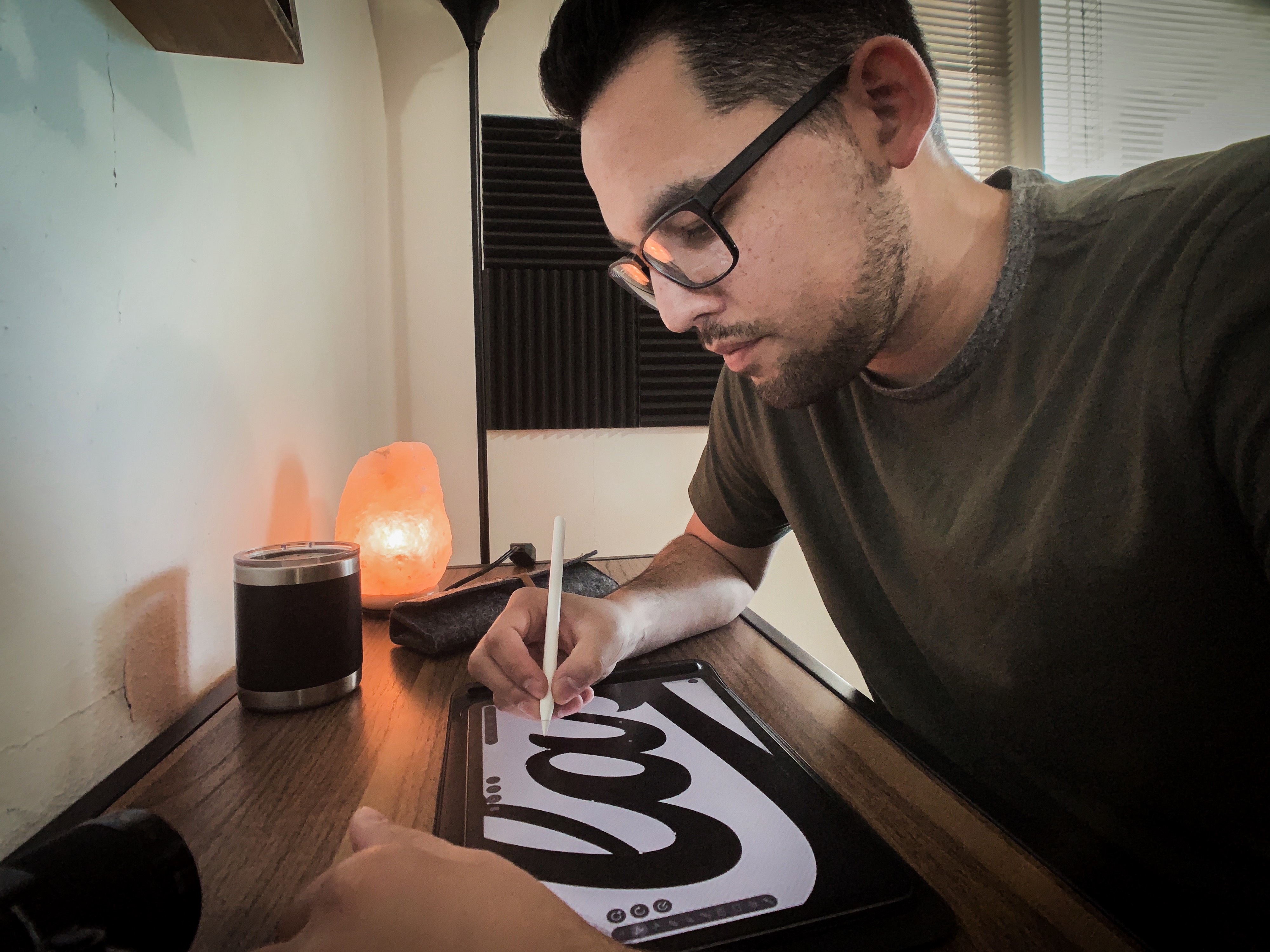 Person working on a graphic design on a tablet in a home setting