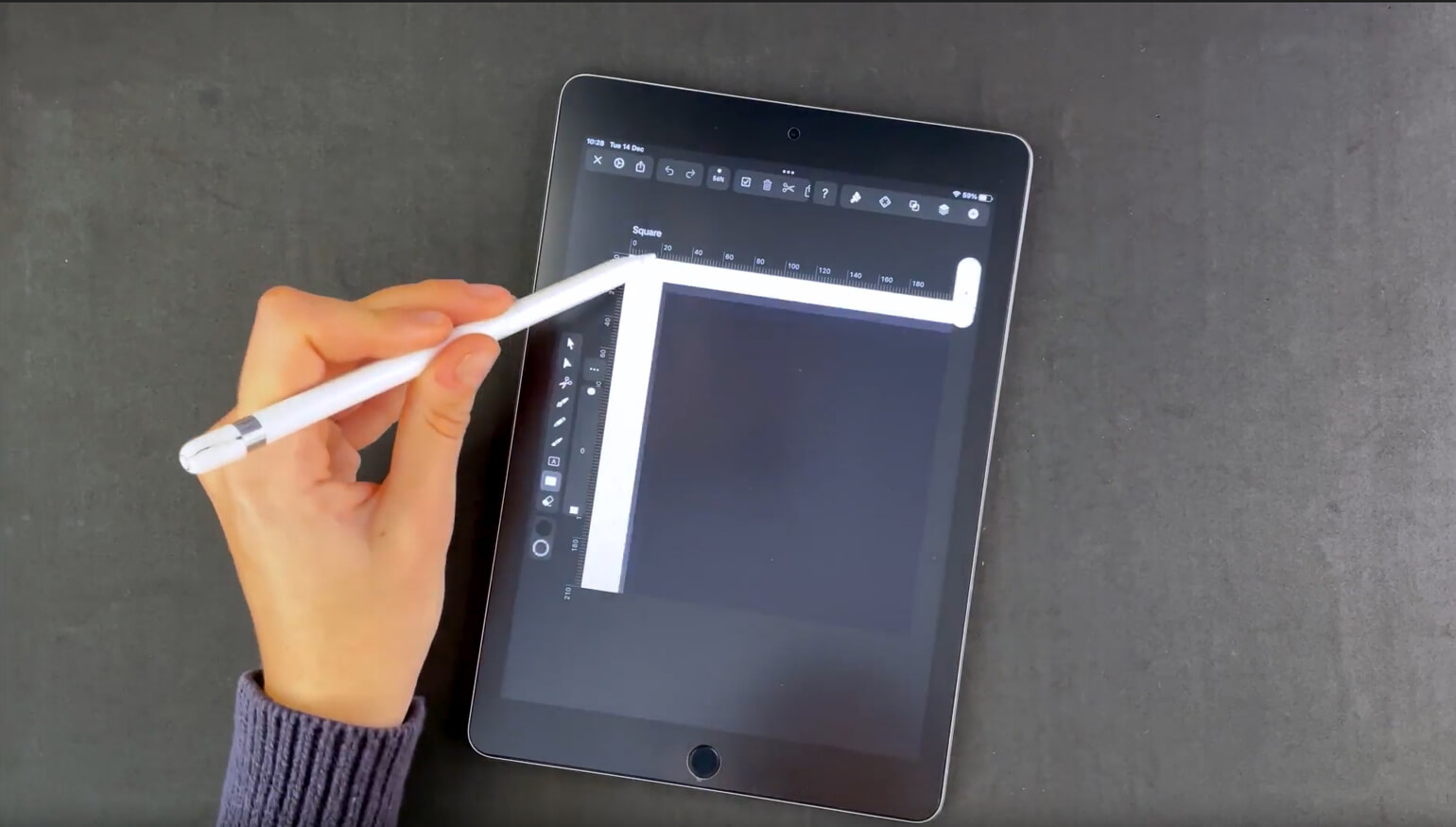 Hand with stylus drawing a line on a digital tablet with design software