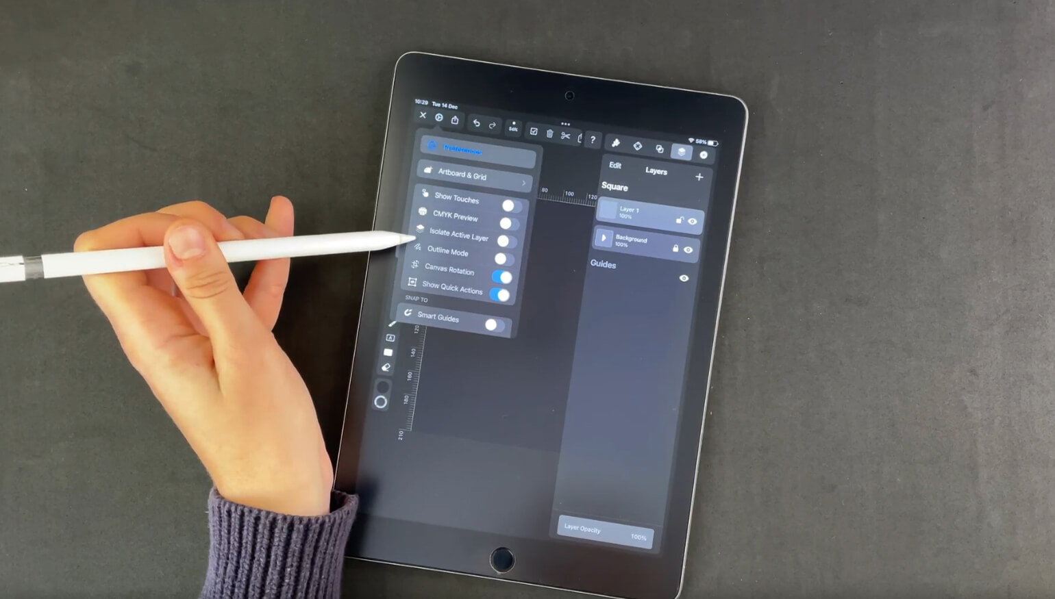 Hand holding a stylus navigating through a menu on a graphic design app on a tablet