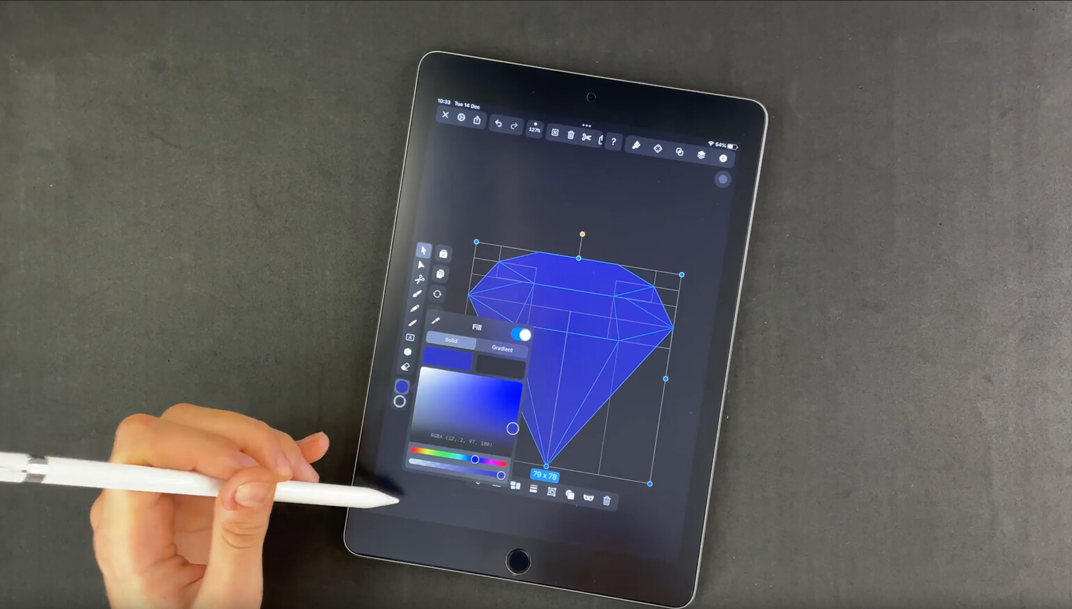 Hand using stylus to color a diamond drawing on a tablet