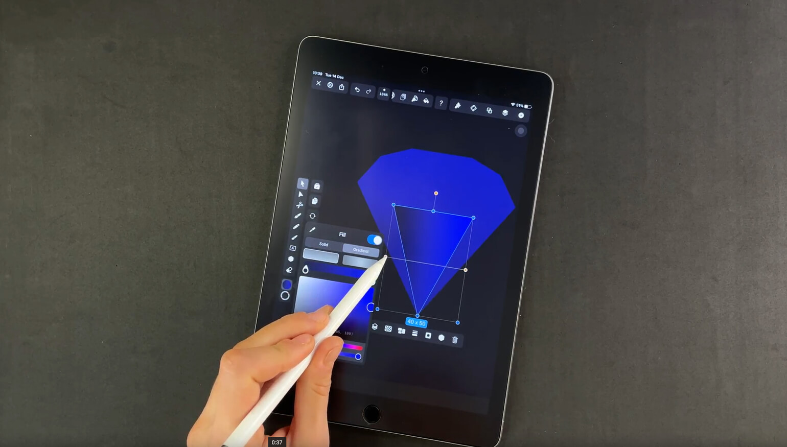 Hand applying gradient fill to a diamond illustration on a digital tablet