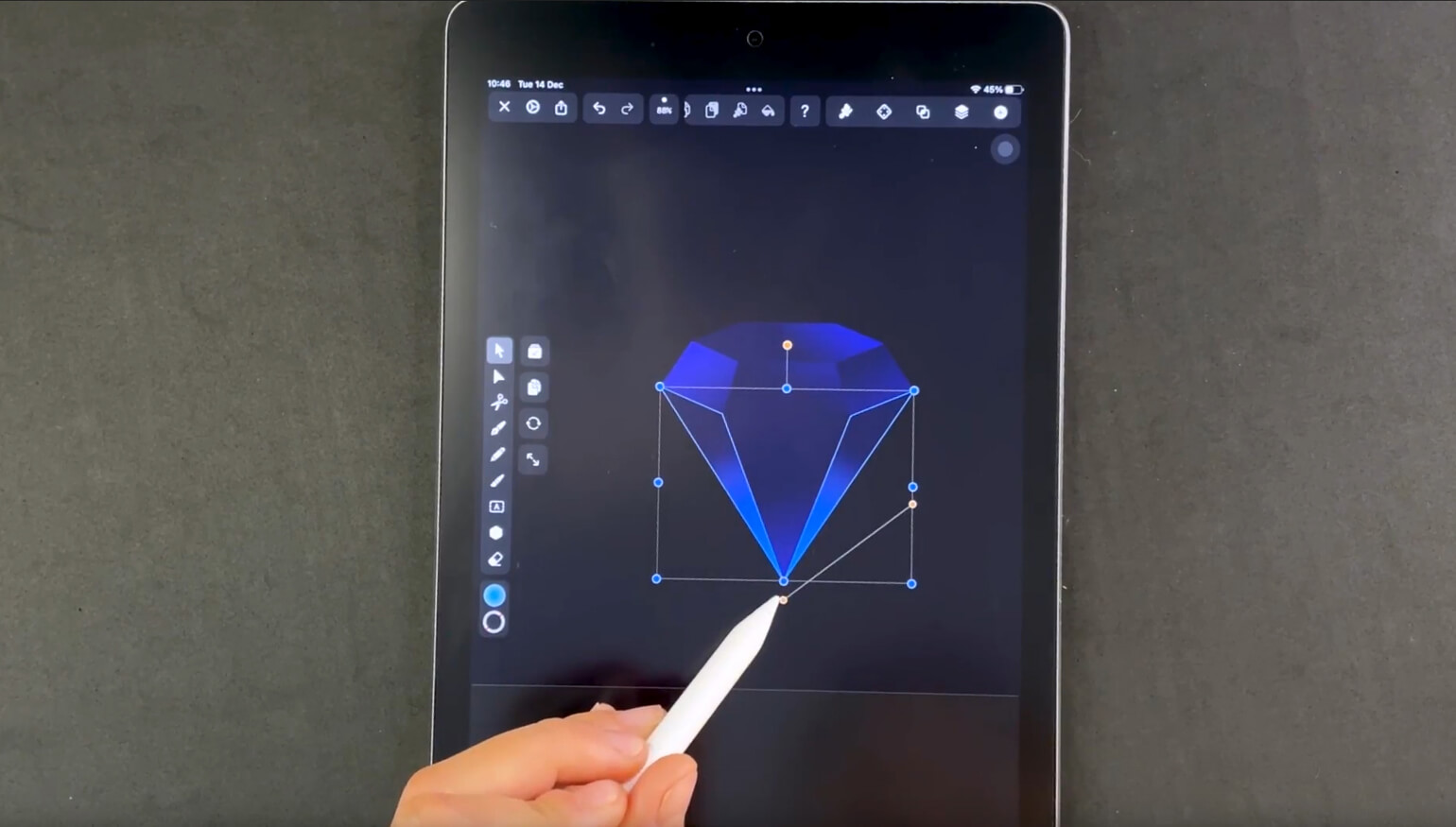 Hand with stylus adjusting a diamond shape on a graphic design app on a tablet