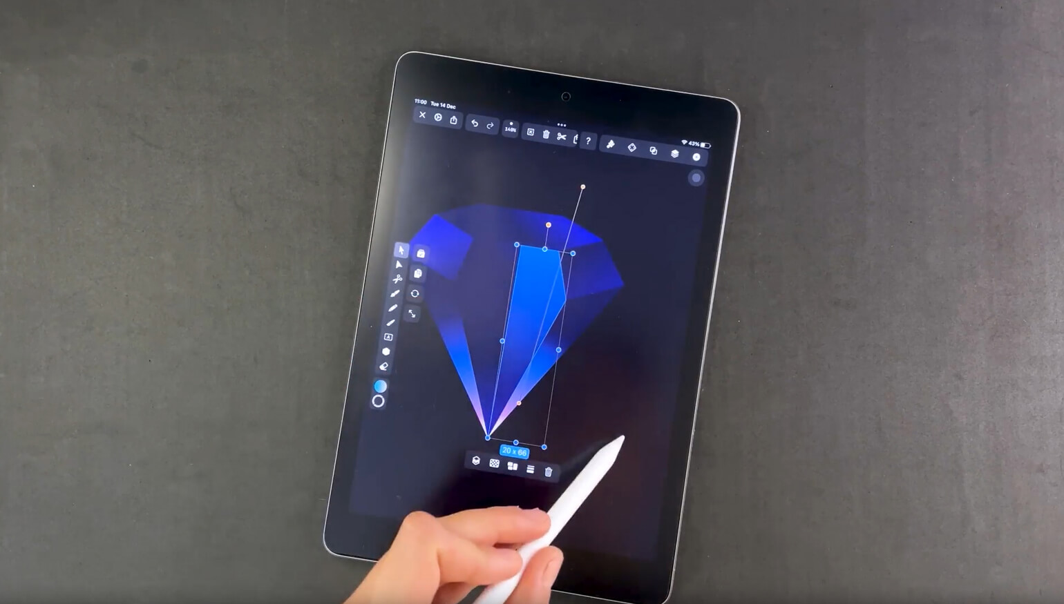 Hand with stylus adjusting a graphic of a blue diamond on a digital tablet