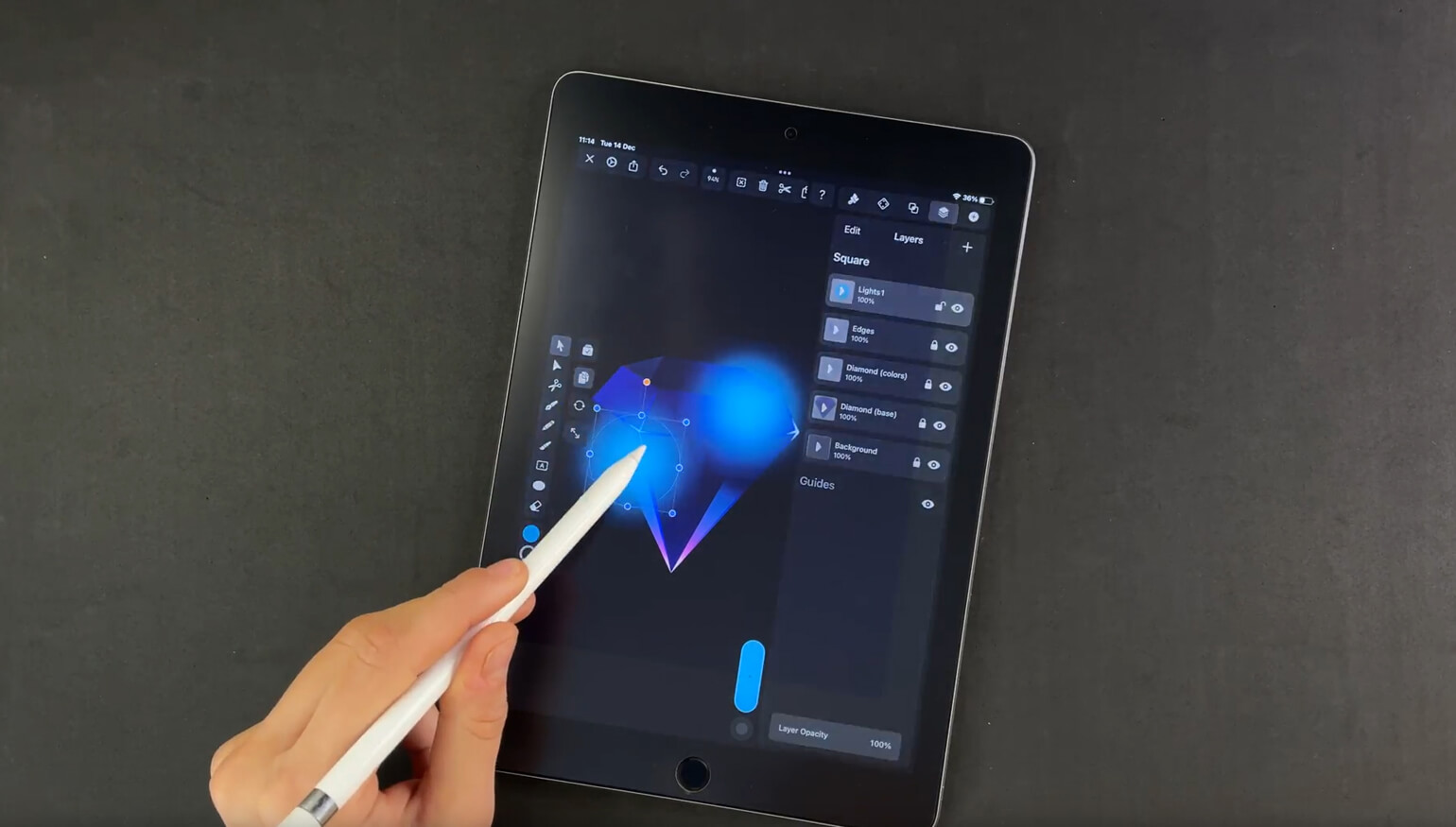 Hand holding a stylus to a tablet with graphic design software open, lights effect on a geometric shape