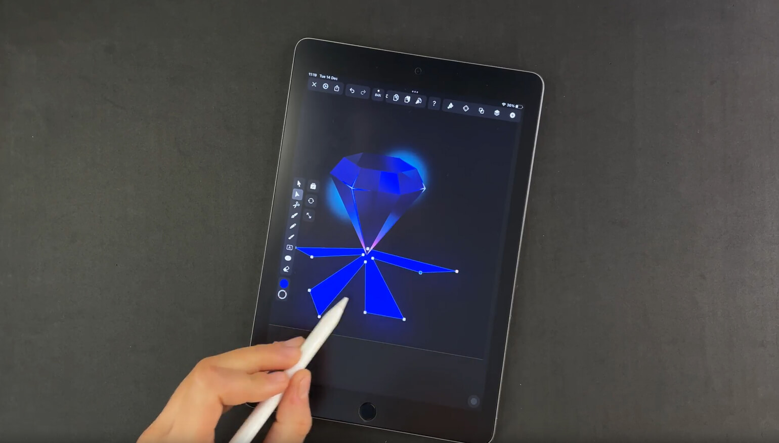 Hand holding a stylus drawing a diamond shape with reflection lines on a digital tablet