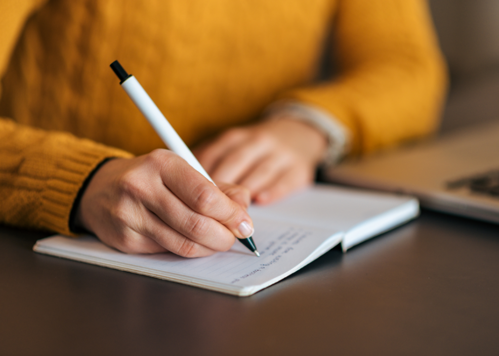 A woman's hand writing in a notebook