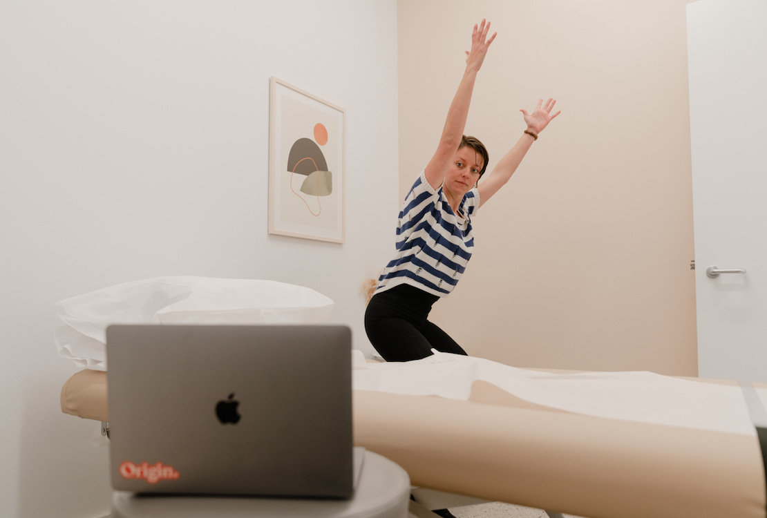 An Origin physical therapist demonstrating an exercise during a virtual visit