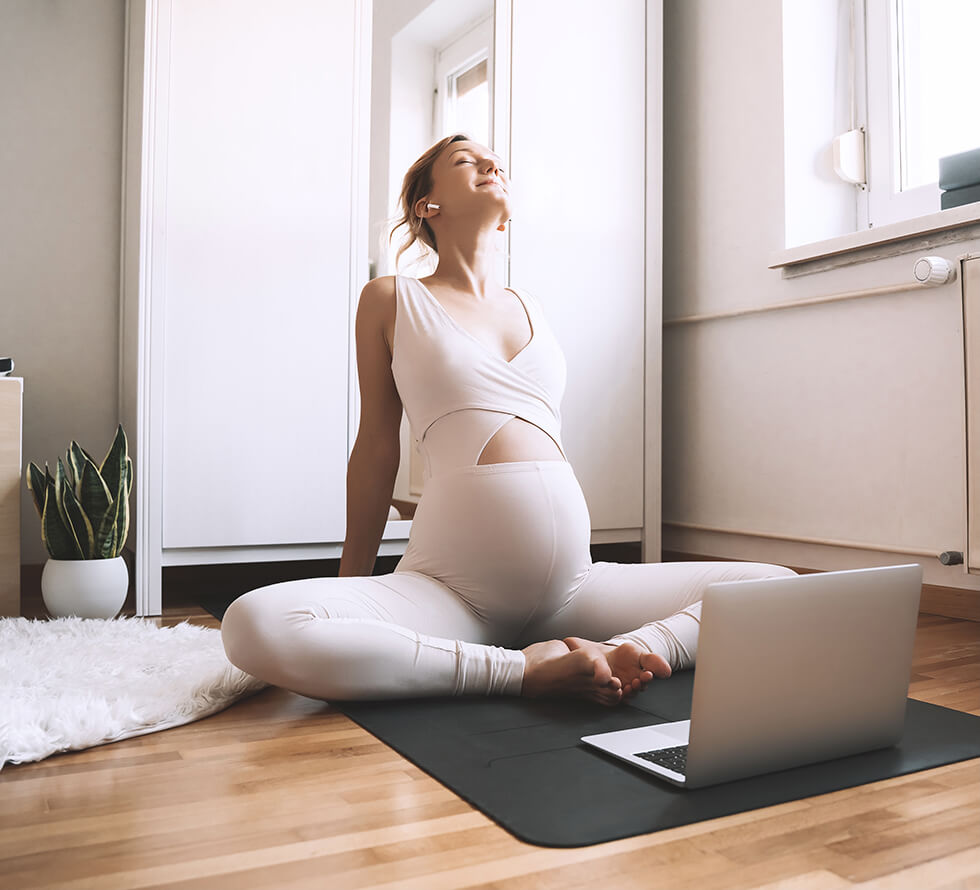 Pregnant Woman Doing Physical Therapy On Computer At Home