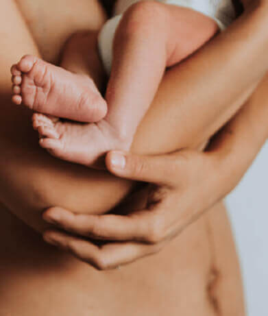 Mother with infant's feet in hands