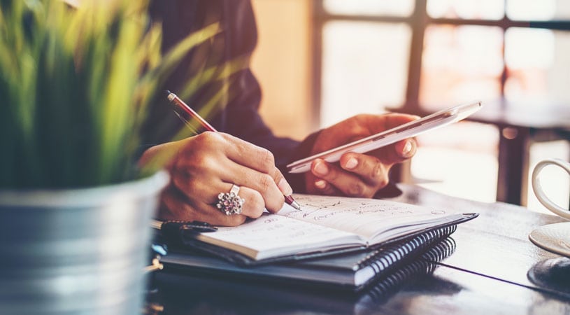 Woman Writing Out A Moving Interstate Checklist