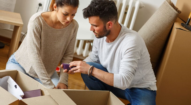 Couple Inspecting Broken Items Damaged By Cheap Removalists