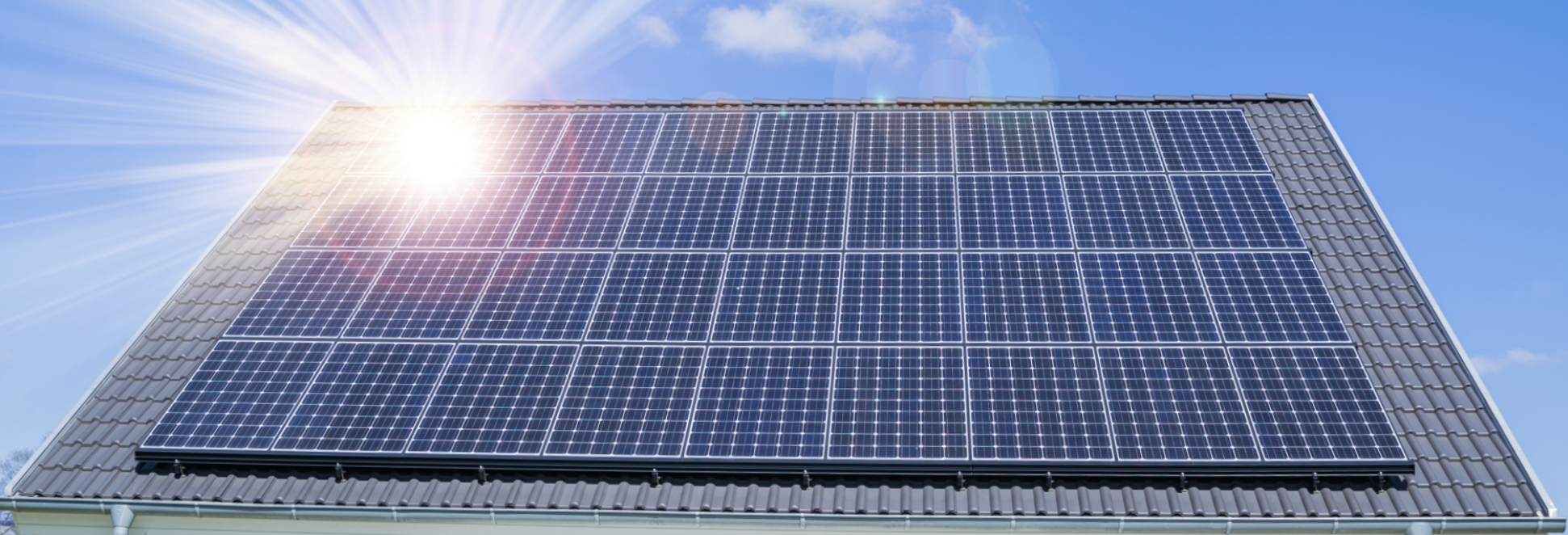 Eine Solaranlage auf einem grauen Dach mit blauem Himmel im Hintergrund, die das Solaranlage Mieten symbolisiert