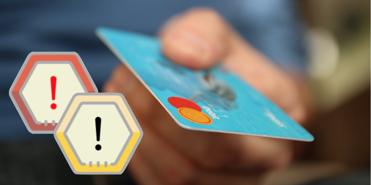 Zwei Warnschilder neben einer Kreditkarte