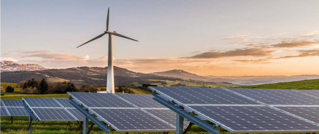 Ein Windkraftrad und Solaranlagen in der Natur, die unser Grünstrom symbolisieren