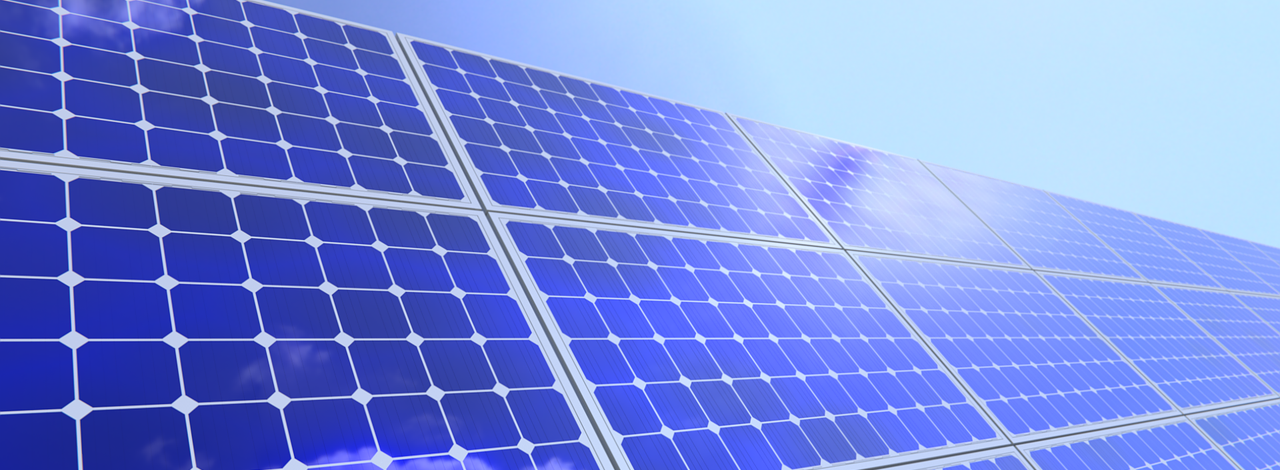 Solarzellen stehen im schrägen Winkel mit blauem Himmel im Hintergrund und symbolisieren die Solarenergie