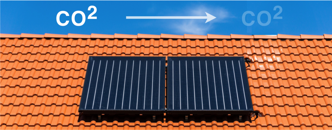 Zwei Flachdachkollektoren auf einem roten Dach mit weißem Pfeil und CO2 Symbol, die die CO2 Reduktion der Solarthermie symbolisieren.