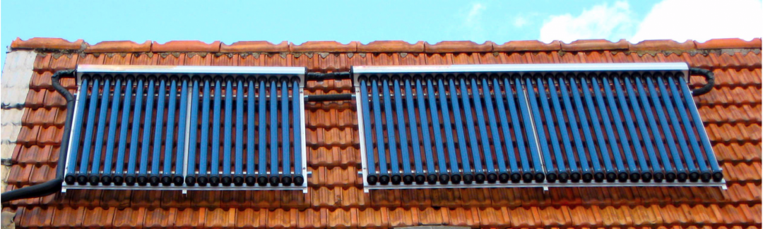Röhrenkollektoren der Solarthermie auf einem roten Dach