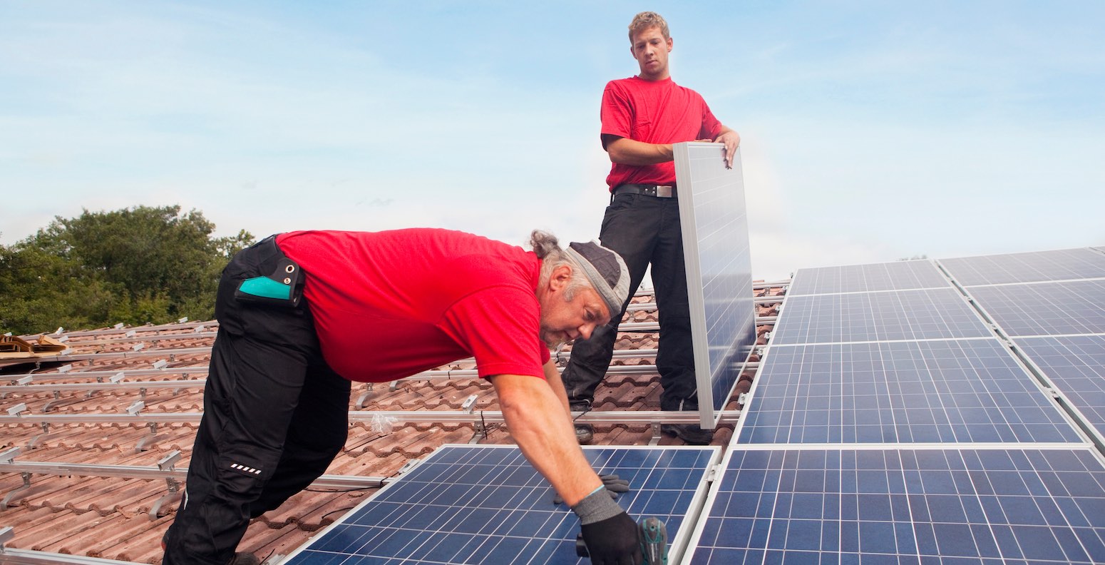 Familie mit Solaranlage auf dem Dach